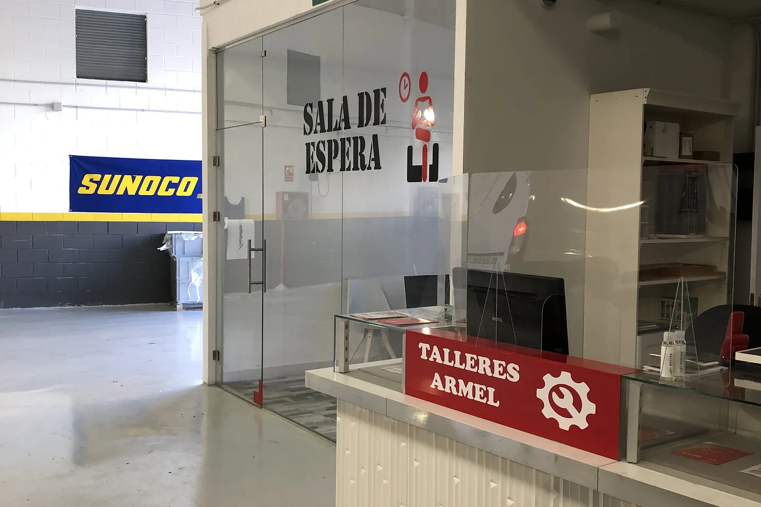 Mostrador de recepción de Talleres Armel junto a la sala de espera acristalada